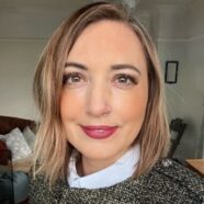 A headshot of Mel smiling at the camera