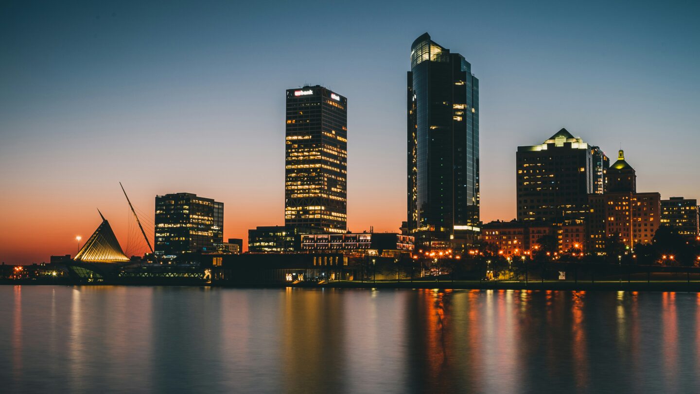 A sunset photo of the Milwaukee city skyline, over the Milwaukee river