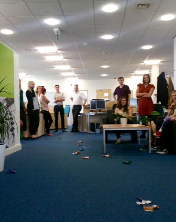 An image of ten YHEC staff spectating a paper airplane competition in the YHEC office